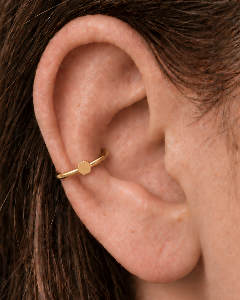 A polished hexagon adds a structured geometric accent that still feels easy to wear. Made for fully healed conch piercings, it pairs the larger hoop silhouette of a conch ring with a small fixed motif for a more distinctive ear stack. Handmade to order in 14ct solid gold, it fits naturally with structured, geometric and modern styling rather than reading as a generic plain hoop.