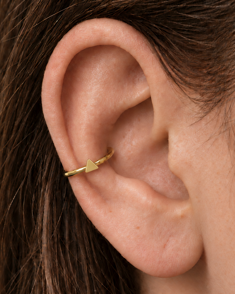 A small triangle gives the hoop a sharper geometric detail with a clean modern feel. Made for fully healed conch piercings, it pairs the larger hoop silhouette of a conch ring with a small fixed motif for a more distinctive ear stack. Handmade to order in 14ct solid gold, it fits naturally with clean, geometric and modern styling rather than reading as a generic plain hoop.