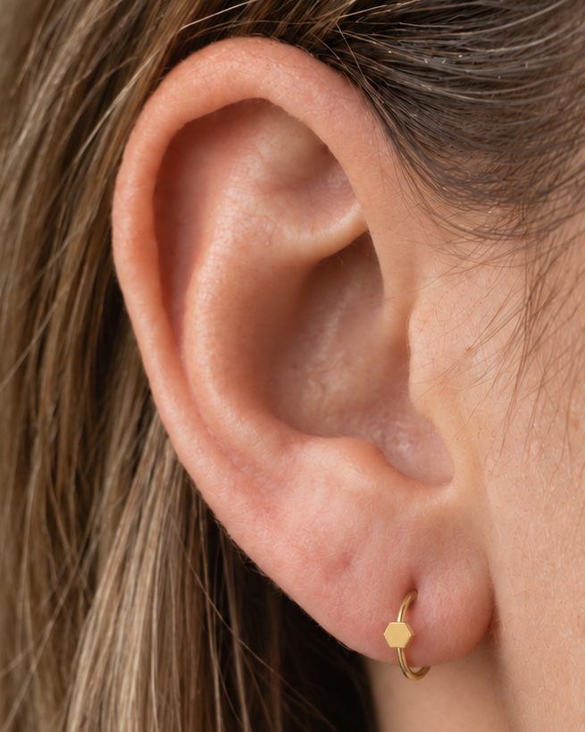 A polished hexagon adds a structured geometric accent that still feels easy to wear. Made for fully healed lobe piercings and sold individually, it works easily in first, second or third-lobe stacks. Handmade to order in 14ct solid gold, it fits naturally with structured, geometric and modern styling rather than reading as a generic plain hoop.