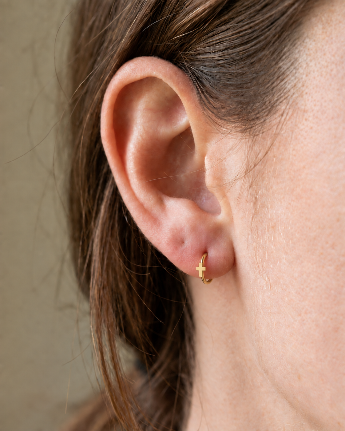 A polished cross gives the hoop a clean symbolic detail without stones, enamel or dangling parts. Made for fully healed lobe piercings and sold individually, it works easily in first, second or third-lobe stacks. Handmade to order in 14ct solid gold, it fits naturally with clean, symbolic and understated styling rather than reading as a generic plain hoop.