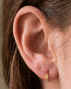 A softly rounded heart adds a sweet, personal detail to a simple gold hoop. Made for fully healed lobe piercings and sold individually, it works easily in first, second or third-lobe stacks. Handmade to order in 14ct solid gold, it fits naturally with soft, personal and romantic styling rather than reading as a generic plain hoop.