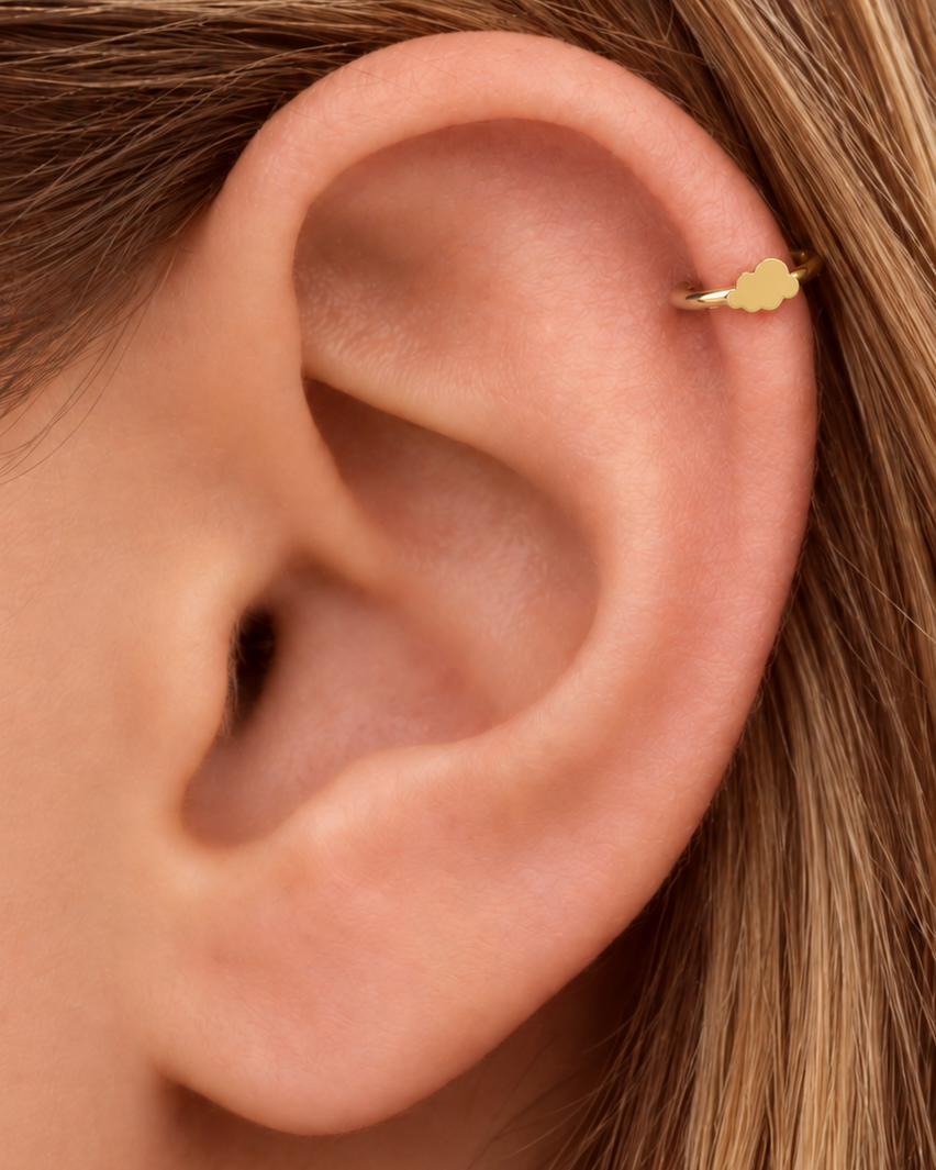 A softly rounded cloud adds a playful sky-inspired detail while keeping the scale small. Made for fully healed helix piercings, it keeps the profile compact for an upper-ear stack while leaving the motif clearly visible. Handmade to order in 14ct solid gold, it fits naturally with soft, playful and sky-inspired styling rather than reading as a generic plain hoop.