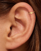 This miniature cat head has two ears, a softly rounded face and small whiskers extending from either side. The polished surface has no engraved eyes or nose and no gemstones, keeping the feline outline simple and clear.