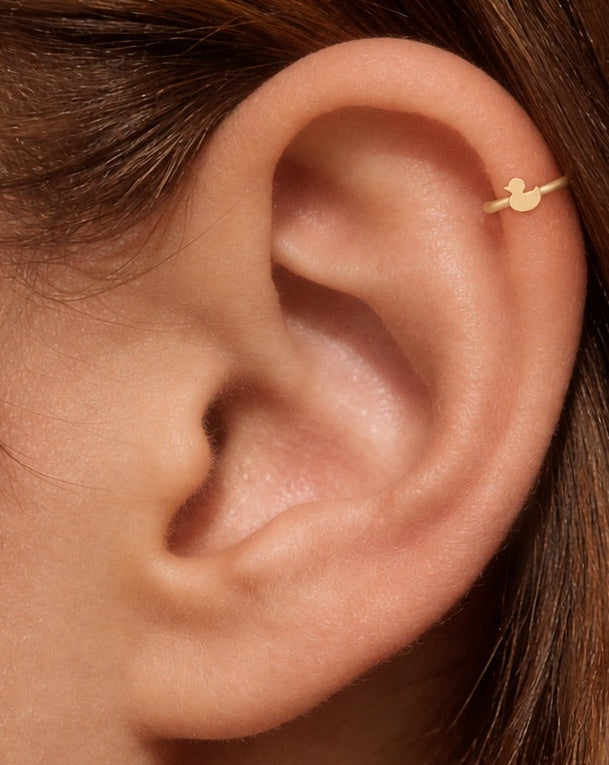 This miniature duck is shown in profile, with a round head, a small projecting bill and a curved body that ends in an upturned tail. Its smooth, polished surface has no engraved eyes, wing patterns or gemstones, keeping the silhouette simple and clear.

Handmade to order in nickel-free 14ct solid gold, this duck helix hoop is available in yellow, white or rose gold. Choose a 5, 6 or 7mm internal diameter and 18G (1.0mm) or 20G (0.8mm). The motif measures approximately 3mm. Designed for fully healed helix pi