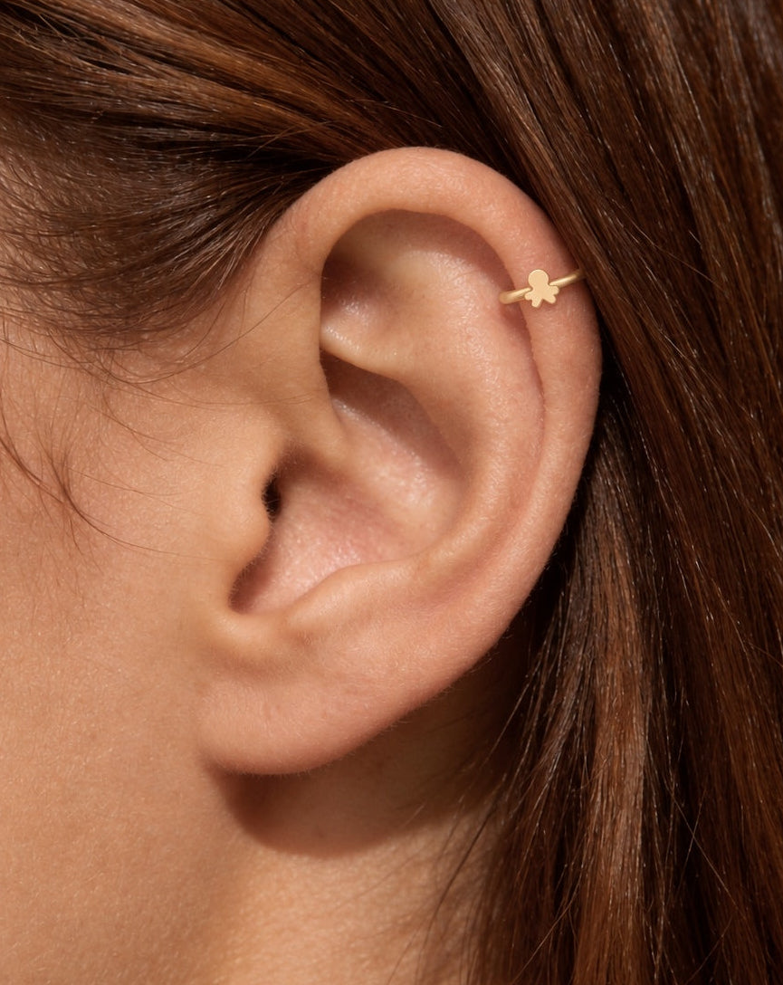 This stylised miniature octopus has a large rounded head and four short arm shapes extending around the lower edge. Its smooth, polished surface has no engraved eyes, sucker details or gemstones, keeping the silhouette clear and minimal.

Handmade to order in nickel-free 14ct solid gold, this octopus helix hoop is available in yellow, white or rose gold. Choose a 5, 6 or 7mm internal diameter and 18G (1.0mm) or 20G (0.8mm). The motif measures approximately 3mm. Designed for fully healed helix piercings, wit