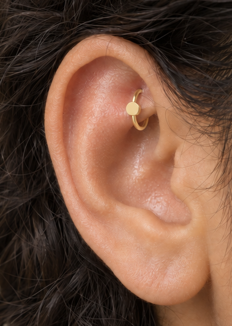 A simple circle motif keeps the design pared back, rounded and easy to mix with other jewellery. Made for fully healed traditional rook piercings, it gives a small curved ear placement a clear motif-led detail while keeping the hoop clean and wearable. Handmade to order in 14ct solid gold, it fits naturally with simple, rounded and minimal styling rather than reading as a generic plain hoop.