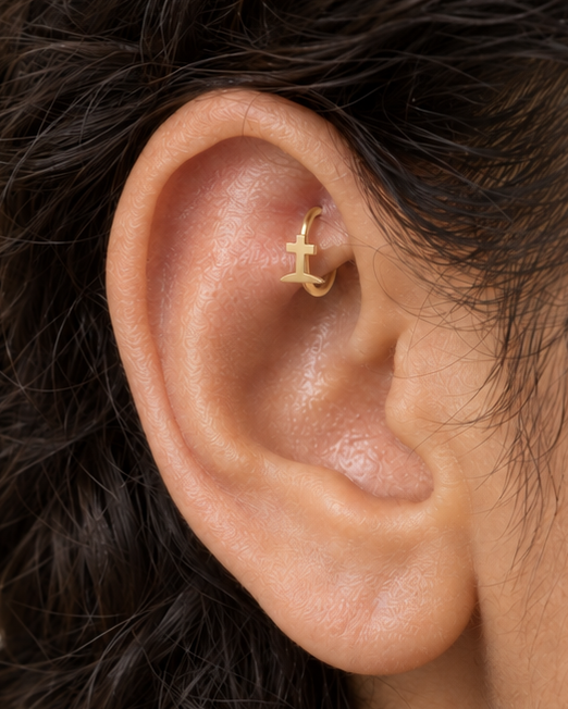 A graveyard-style cross gives the hoop a darker gothic reference that is distinct from the simpler cross design. Made for fully healed traditional rook piercings, it gives a small curved ear placement a clear motif-led detail while keeping the hoop clean and wearable. Handmade to order in 14ct solid gold, it fits naturally with gothic, spooky and alternative styling rather than reading as a generic plain hoop.