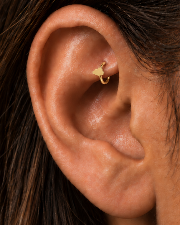 A softly rounded cloud adds a playful sky-inspired detail while keeping the scale small. Made for fully healed traditional rook piercings, it gives a small curved ear placement a clear motif-led detail while keeping the hoop clean and wearable. Handmade to order in 14ct solid gold, it fits naturally with soft, playful and sky-inspired styling rather than reading as a generic plain hoop.