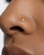 This miniature snowflake has six arms radiating from a solid centre, each with small branches and rounded ends. The spaces between the arms define the shape, while the smooth gold surface keeps the design simple. There are no gemstones or engraved details.

Handmade to order in nickel-free 14ct solid gold, this snowflake nostril hoop is available in yellow, white or rose gold. Choose a 6, 7, 8, 9 or 10mm internal diameter and 18G (1.0mm) or 20G (0.8mm). The motif measures approximately 3mm. Designed for ful