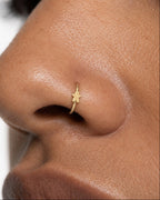This miniature gingerbread man has a round head, two outstretched arms and two separated legs with rounded ends. Its smooth gold surface has no engraved face, buttons or icing patterns, keeping the classic Christmas biscuit silhouette simple and clear.

Handmade to order in nickel-free 14ct solid gold, this gingerbread man nostril hoop is available in yellow, white or rose gold. Choose a 6, 7, 8, 9 or 10mm internal diameter and 18G (1.0mm) or 20G (0.8mm). The motif measures approximately 3mm. Designed for f