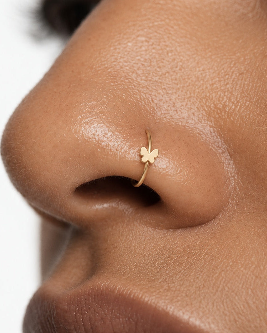 A delicate butterfly detail for your everyday jewellery. This 14ct solid gold butterfly nostril ring pairs an approximately 3mm polished butterfly silhouette with a smooth seamless hoop. Larger upper wings and smaller rounded lower wings create a soft, simple outline, with no gemstones or engraved decoration.
Handmade to order in yellow, white or rose gold, with inner diameters from 6 to 10mm and a choice of 18G (1.0mm) or 20G (0.8mm). Both the butterfly and hoop are solid gold and nickel-free, designed for