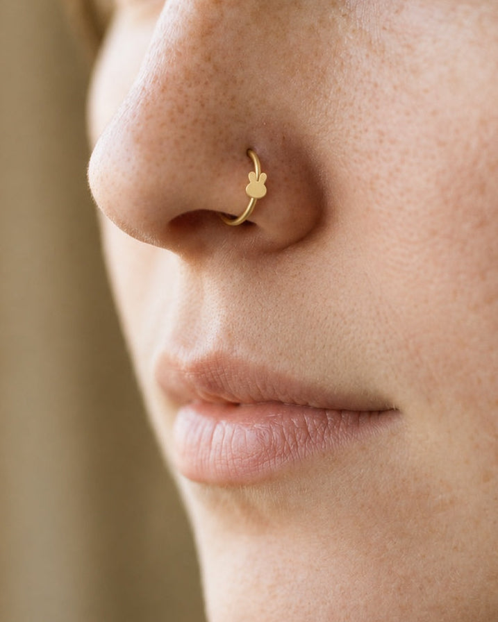 Two little ears, one playful detail. This 14ct solid gold rabbit nostril ring pairs an approximately 3mm polished bunny-head silhouette with a smooth seamless hoop. Upright ears with rounded tips and a softly curved face give the motif its character, with no engraved features or gemstones.
Handmade to order in yellow, white or rose gold, with inner diameters from 6 to 10mm and a choice of 18G (1.0mm) or 20G (0.8mm). Both the rabbit motif and hoop are solid gold and nickel-free, designed for a fully healed n