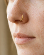 This miniature Christmas tree has a pointed top and three widening tiers, creating a balanced evergreen silhouette. Its smooth polished surface keeps the outline clear, with gently rounded branch corners and a straight lower edge.

Handmade to order in nickel-free 14ct solid gold, this christmas tree nostril hoop is available in yellow, white or rose gold. Choose a 6, 7, 8, 9 or 10mm internal diameter and 18G (1.0mm) or 20G (0.8mm). The motif measures approximately 3mm. Designed for fully healed nostril pie